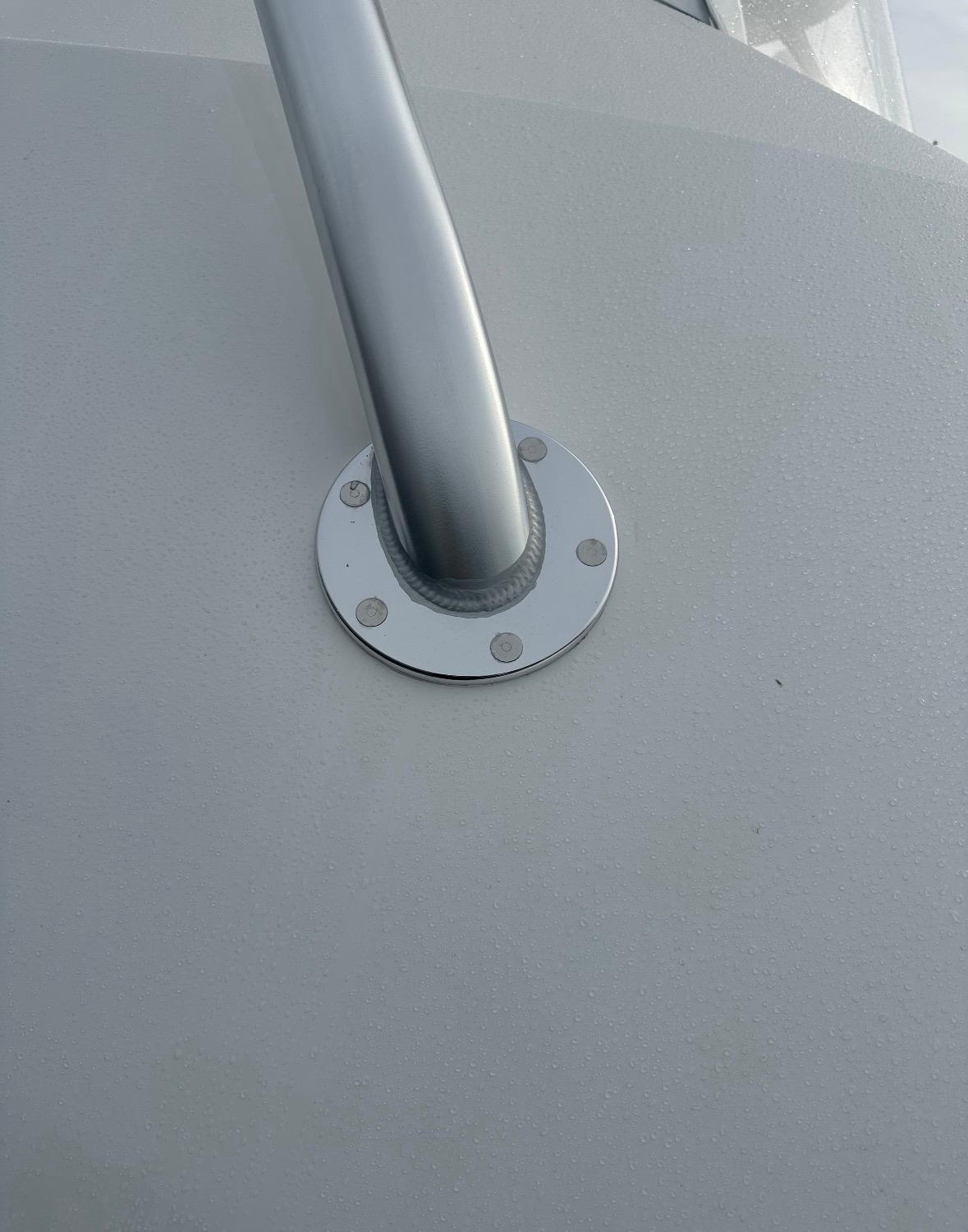 Brushed aluminum tower base with flush fasteners on a yacht deck